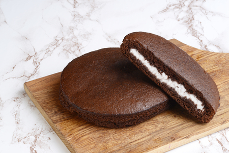 chocolate cream cake on a wood cutting boardの写真素材