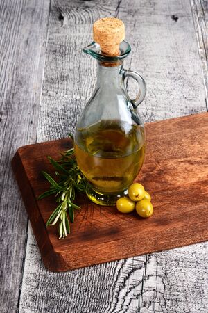 green olives with bottle of oil and herbsの写真素材