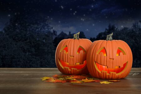 two Halloween pumpkins at night glowingの写真素材
