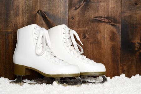 ladies figure skates leaning on woodの写真素材