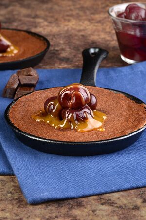 pan of chocolate cake with cherry toppingの写真素材