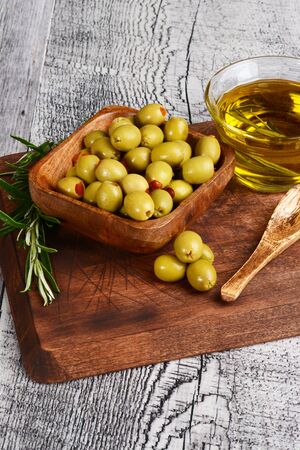 wood bowl of pimento olives with rosemary herbの写真素材