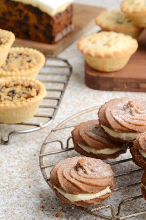 closeup gingerbread cream filled swirl cookies with christmas dessertsの写真素材