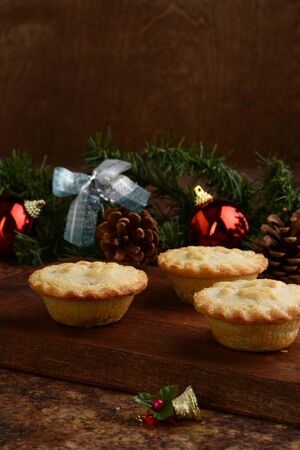 three mincemeat pies on wood cutting boardの写真素材