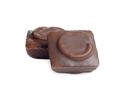 closeup two small chocolate covered cakes on a white backgroundの写真素材