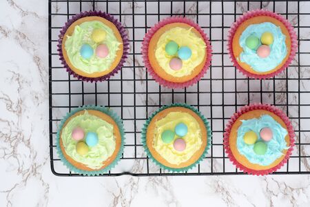 easter cupcakes with eggs cooling on wire rackの写真素材