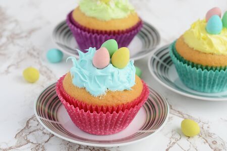closeup easter cupcake with blue frosting and mini eggsの写真素材