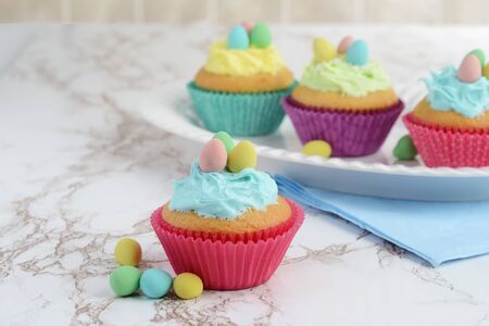 easter cupcakes on a platter with eggsの写真素材