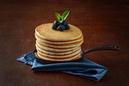 blueberry pancakes in skillet with blue napkinの写真素材