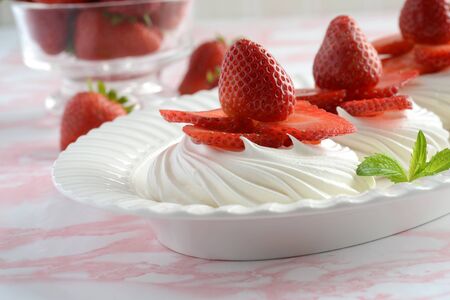 closeup meringue nests with fresh strawberries and mintの写真素材