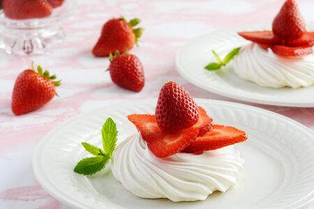 closeup strawberry meringue nests on a plate with mintの写真素材