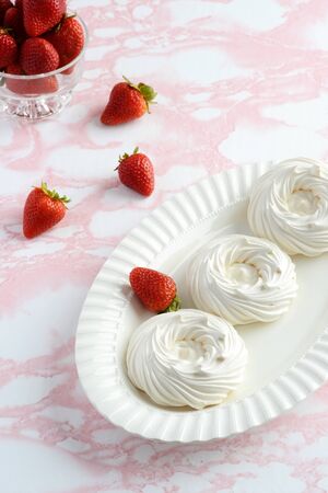 high angle empty meringue nests on a platter with strawberriesの写真素材