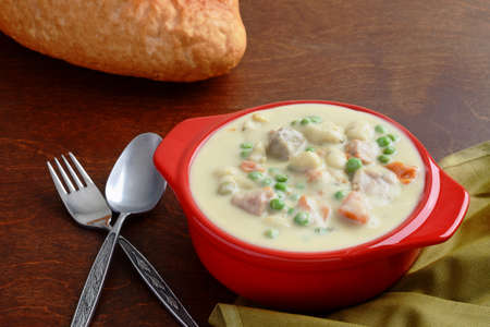 closeup of chicken vegetable cream soup with breadの写真素材
