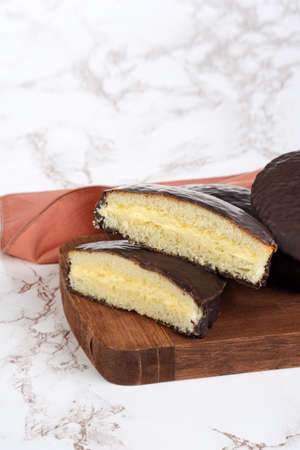 closeup of custard filled chocolate sponge cake with a napkinの写真素材