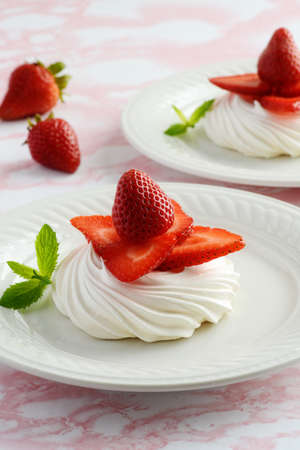 closeup fresh strawberries meringue nest and mintの写真素材