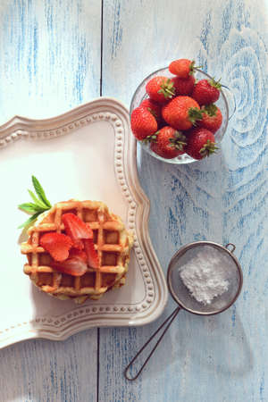 top view Belgian waffles with strawberries on a plateの写真素材