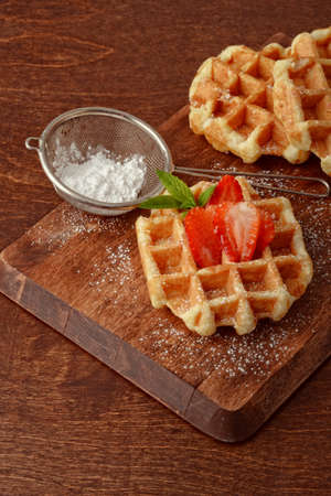 Belgian waffles with strawberries and icing sugarの写真素材
