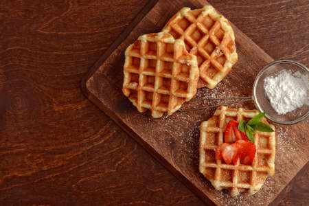 fresh hot belgian waffles on cutting boardの写真素材