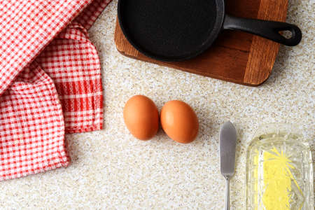 high angle brown eggs with cast iron frying pan and butterの写真素材
