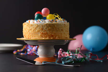 vanilla crumble birthday cake with balloon on blackの写真素材