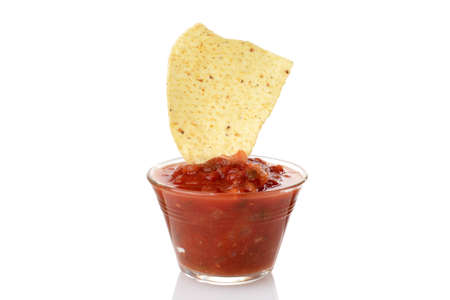 nacho chip dipped in bowl of salsaの写真素材