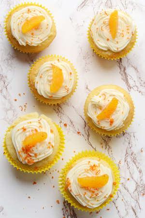 high angle view orange vanilla cream cupcakesの写真素材