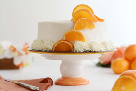 closeup of vanilla cake with orange slices on cake standの写真素材