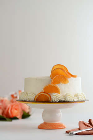 vanilla cake with orange slices on a cakestandの写真素材