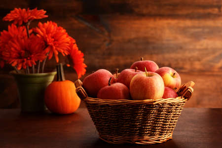 royal gala apples in basket with pumpkin and flowersの写真素材