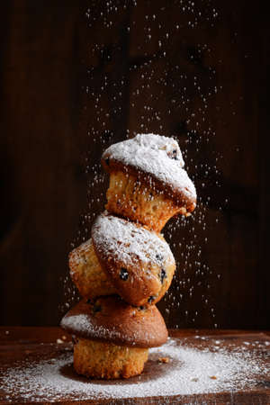 closeup of stack of blueberry muffins with powdered sugar fallingの写真素材