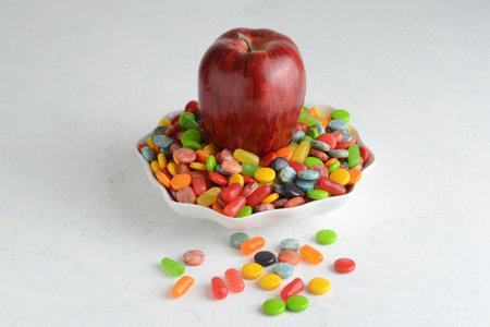red delicious apple in bowl of candy