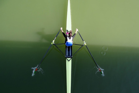 Girl rowing with canoe in green water