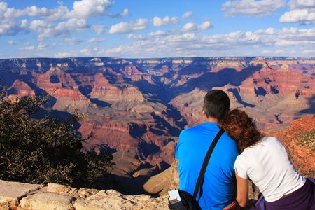 Young Couple Sitting on cliff watching tp the Grand Canyonの写真素材