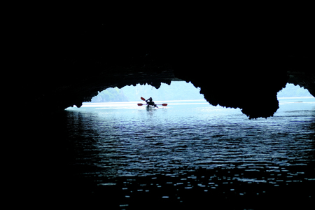 Two backpackers on kayak paddling through caves and dense jungle in Halong Bay / Cat Ba island areas in Vietnam.の写真素材