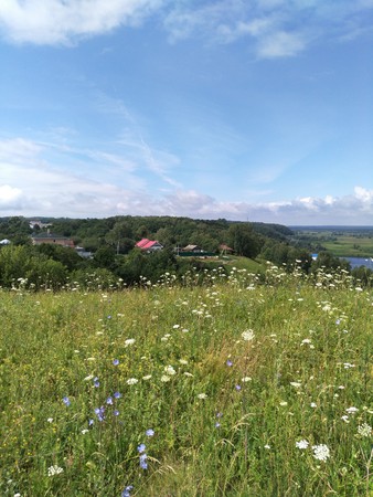 blue sky with clouds over blooming hillsの写真素材