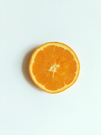 slice of orange in the center of white backgroundの写真素材