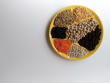multicolored beans on a big yellow plate on white backgroundの写真素材