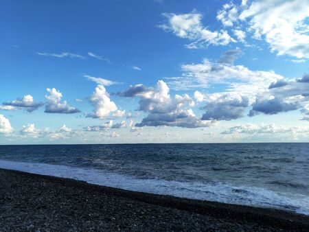 a series of rain clouds over the sea surface at sunsetの写真素材