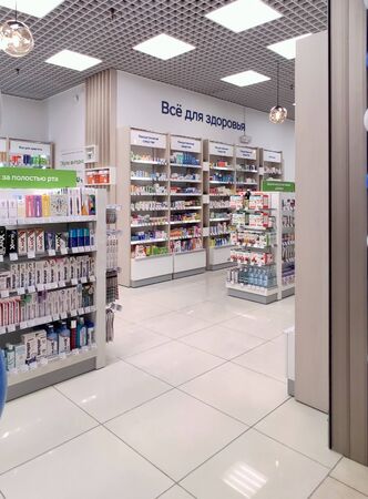 Moscow, Russia-Sept. 5, 2019: All for health, medicine, all for beauty, dietary Supplements, oral care, vitamins buy profitably. The assortment of pharmacies, vitamins boxes and bottles of medicines are laid out on the shelves of the showcase. White wall のeditorial素材