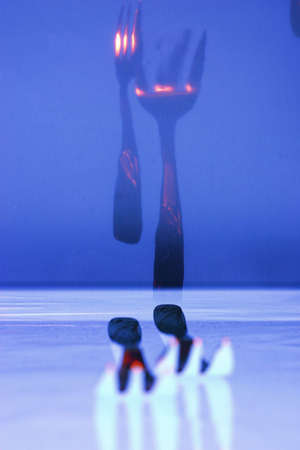 Two forks on the table. On blue film lightbox.の写真素材