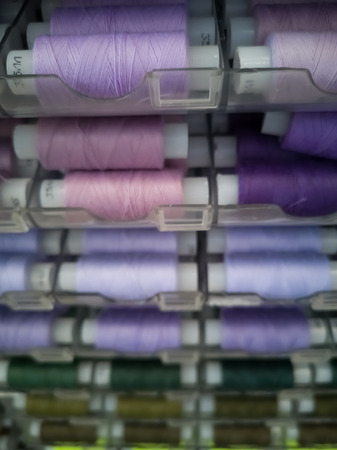 Many threads of different colors on plastic bobbins for sewing, for needlework. Abstract background...