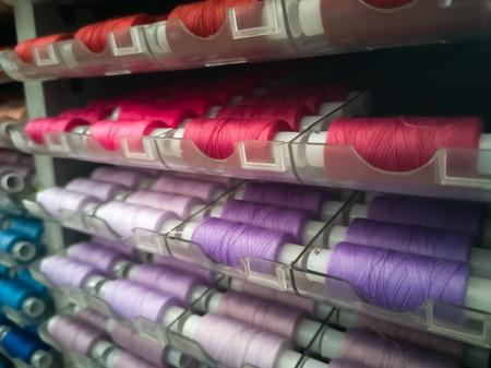 Many threads of different colors on plastic bobbins for sewing, for needlework. Abstract background...