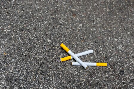 three cigarettes lying on the pavement.の写真素材