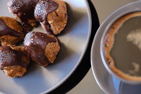 Anthill chocolate cake dessert on a gray plate and cup of coffee. Black table in the kitchen. Bakeryの写真素材