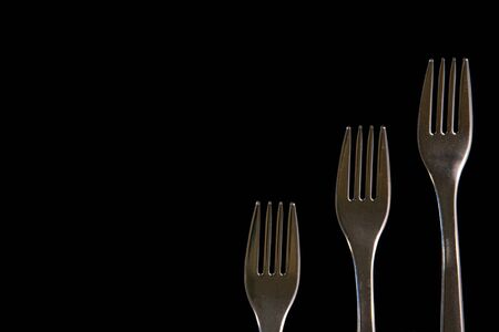 metal forks on a black background. top view on stainless forks with copy space.の写真素材