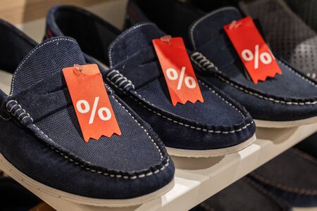 rack with  discounted shoe in a store. 50% sale on footwear in the supermarket.の写真素材
