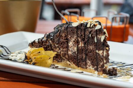 sweet chocolate cake on a wooden table in a cafe.