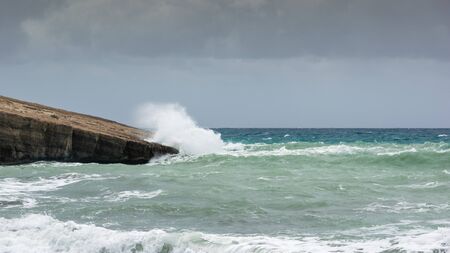 Waves in a small bay of the Aegean Sea in Rhodes in summer day.