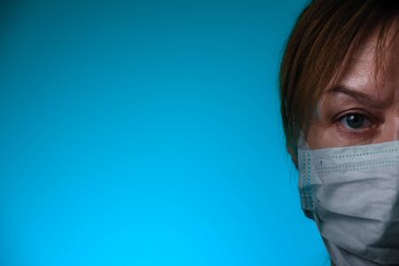 Woman wearing medical masks on blue background. Medical surgical flu illness protective mask...