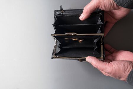 Man opens and holding empty wallet with some coins. money is over due to quarantine.